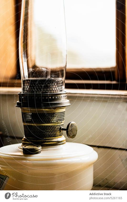 Kerosene lamp near wooden window vintage utensil interior retro glass decor old style home old fashioned metal lantern object house detail gold classic