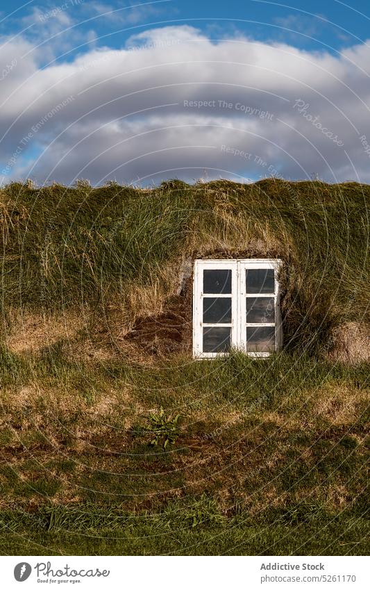 Window of Icelandic turf house exterior building rural nature cottage countryside roof grass dwell cloudy iceland sky grassy landscape construction facade small