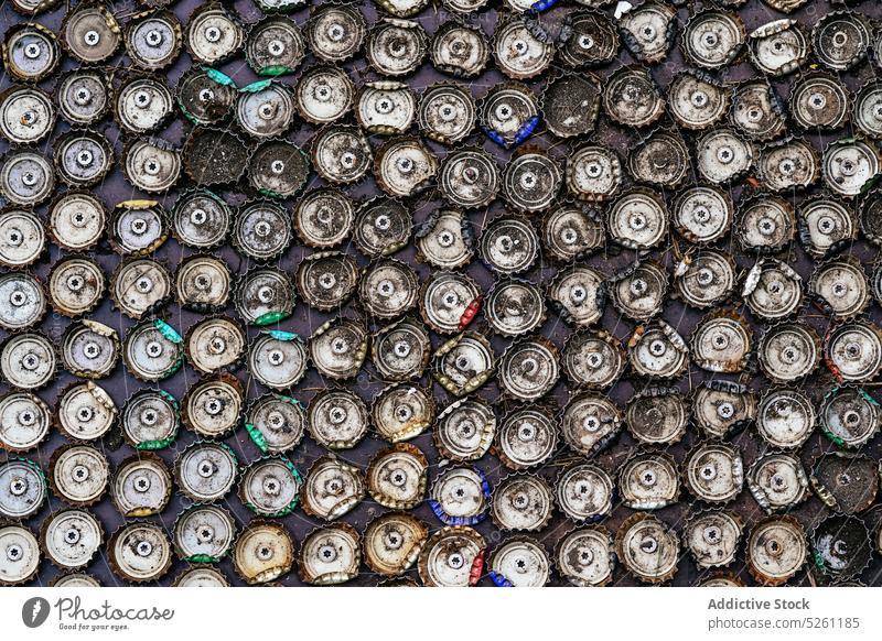 Abstract background of pile of metal bottle caps on wall decor used abstract design street recycle old decoration vintage texture shanny weathered surface urban