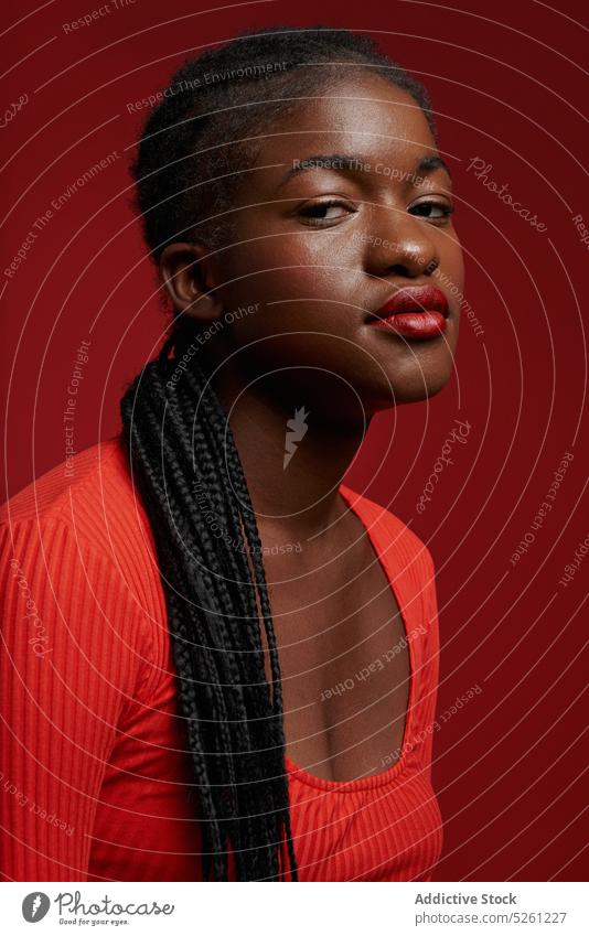 Confident African American woman in red outfit style model confident personality dreadlocks appearance fashion self assured serious female long hair young