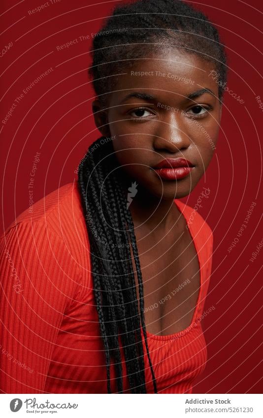 Confident African American woman in red outfit style model confident personality dreadlocks appearance fashion self assured serious female long hair young