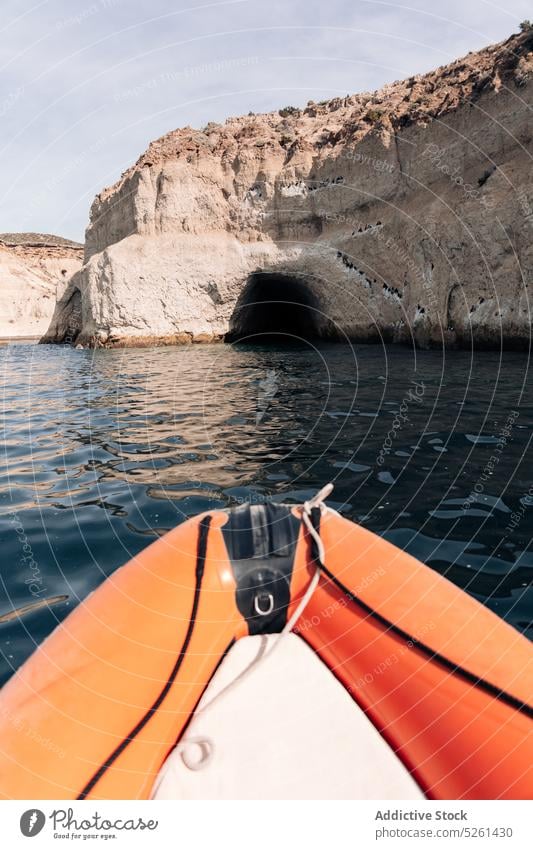 Rubber boat floating into cave cliff sea water nature rock formation picturesque swim rocky vacation ocean marine stone vessel sun scenic ripple environment