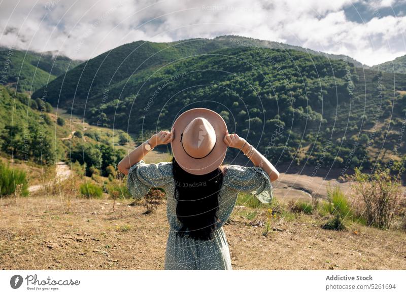 Female tourist in straw hat standing in mountains woman traveler sunset nature admire destination landscape breathtaking tourism young dress harmony carefree