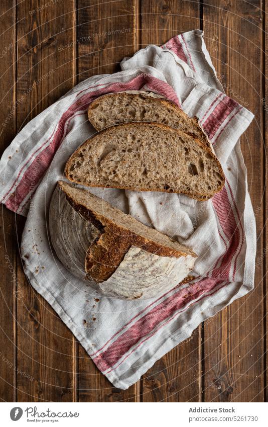 Cut rye bread loaf on towel artisan cut slice rustic table food half baked sourdough natural bakery organic nutrition rural country tradition wood wheat