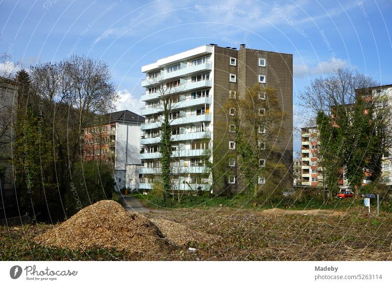 High-rise building with balconies in the style of the post-war period in a residential area and neighborhood with blue sky and sunshine in Wuppertal on the river Wupper in Bergisches Land in North Rhine-Westphalia, Germany
