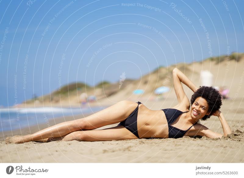 Content black woman lying on beach sunbath shore bikini sea suntan seashore sunny leisure recreation tropical rest trip enjoy summer female ethnic sand