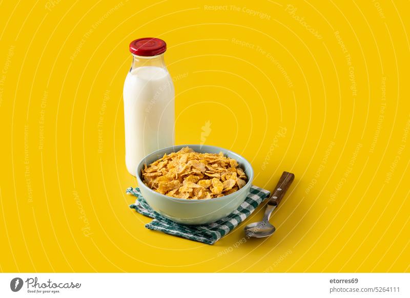 Bowl with cereals and milk bottle for breakfast on yellow background bowl champions clean corn cornflakes crunchy daily delicious diet eat food frosted healthy