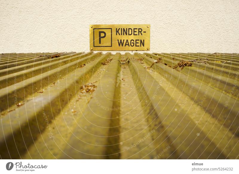 P KINDERWAGEN is written on a sign above a corrugated iron roof / stroller parking area Stroller parking Parking lot Corrugated iron roof means of transport