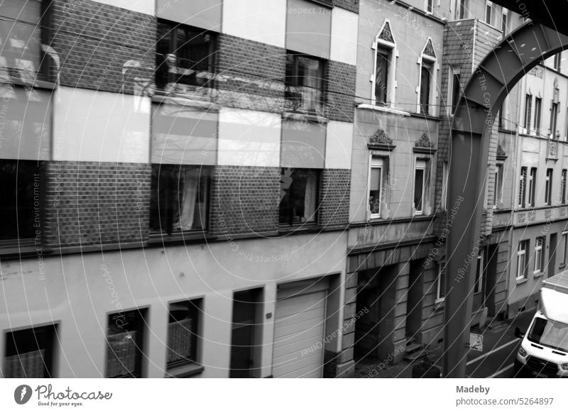 Gray facades of the old houses along the route of the Wuppertal suspension railroad in rainy weather in the district of Vohwinkel in Wuppertal in the Bergisches Land in neo-realistic black and white