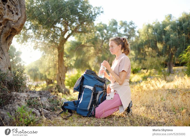 Young woman is packing her backpack during hiking in summer nature. Concepts of adventure, extreme survival, orienteering. Equipments for hike. young backpacker