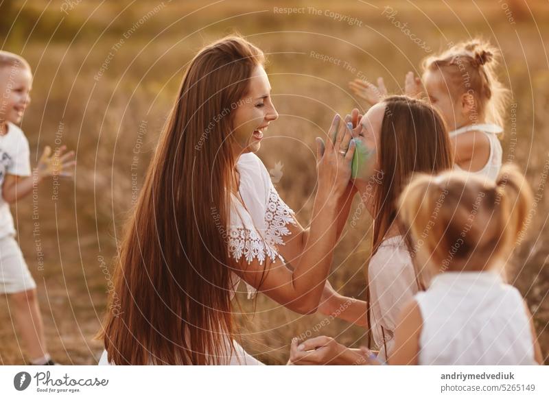 happy young moms playing with their kids outdoors in summer. Happy family time together concept. selective focus. day daughter kissing small walking parents man
