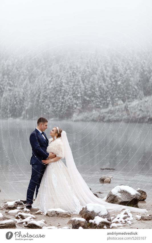 Tender couple in love. brides mountain near the lake in winter frozen landscape nature wedding cold happiness hill happy outdoor caucasian beauty snow alpine