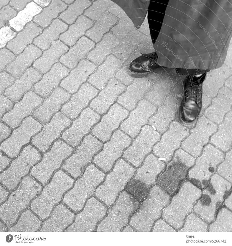Woman in coat next to oil stain on paved surface Coat Oil slick paving off Stone Boots Stand Patch Bent Pattern structure Bird's-eye view