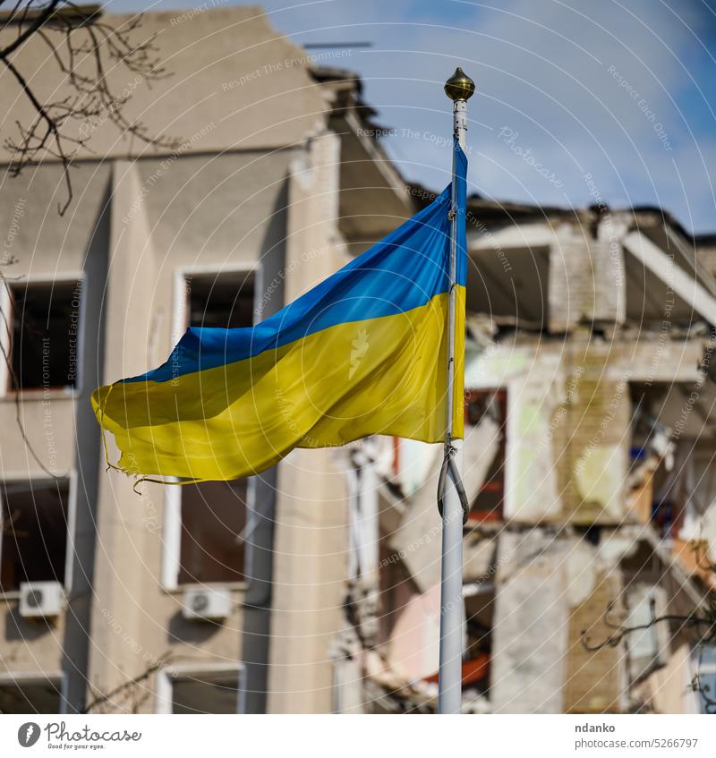 Flag of Ukraine against the background of a destroyed building in Ukraine ukraine ukrainian unbroken urban victory war worn yellow concept patriotism wind