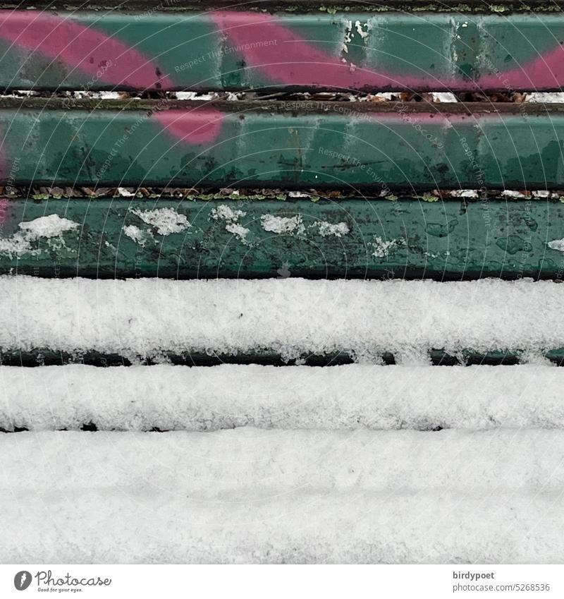 Snow lies on green park bench with graffiti in pink Winter Park bench Graffiti Deserted Exterior shot Colour photo White Cold Bench Calm Ice Day Frost