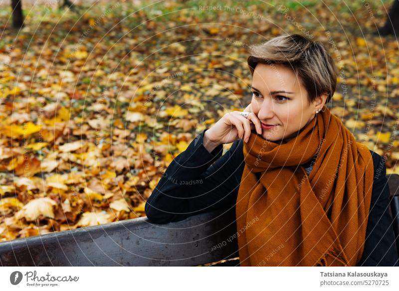 Portrait of a short-haired blonde in a terracotta scarf in an autumn park woman fall female adult Blond Contemplation Watching Attractive real life Lifestyle
