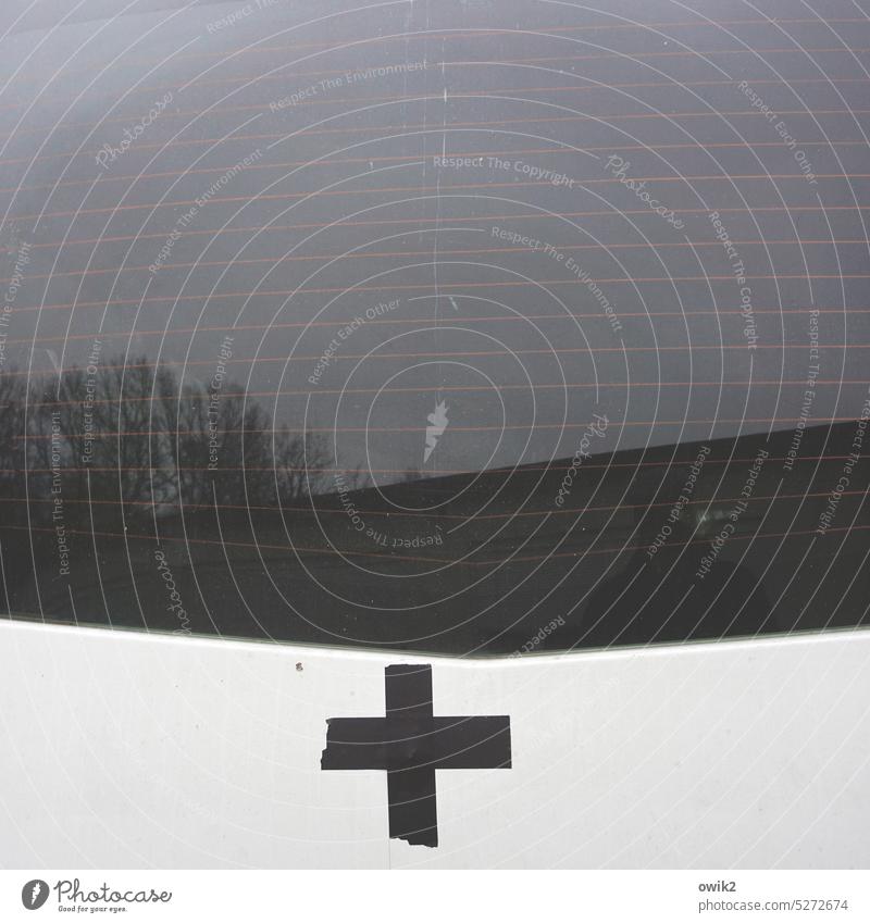 Credo Christian cross pasted adhesive tape Simple makeshift symbol van Transporter Tailgate Window Car Window Window pane Reflection trees Branches and twigs