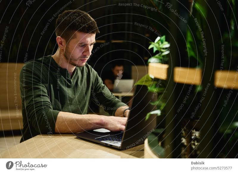 Male hand typing on laptop keyboard in cafe man male freelancer using lifestyle online workplace office adult anonymous browsing business casual computer