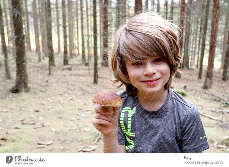 Porcini mushroom found - portrait of boy standing in forest holding porcini mushroom in hand Human being Child Boy (child) Mushroom boletus Forest