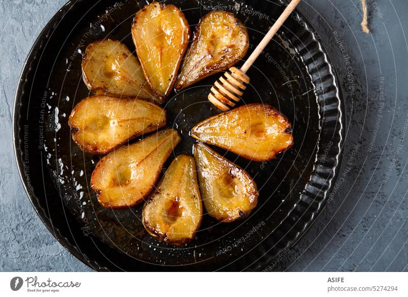 Baked pears with honey in a dark round baking tray roasted baked caramelized dessert breakfast sweet delicious homemade tasty fruit food portion tender juicy