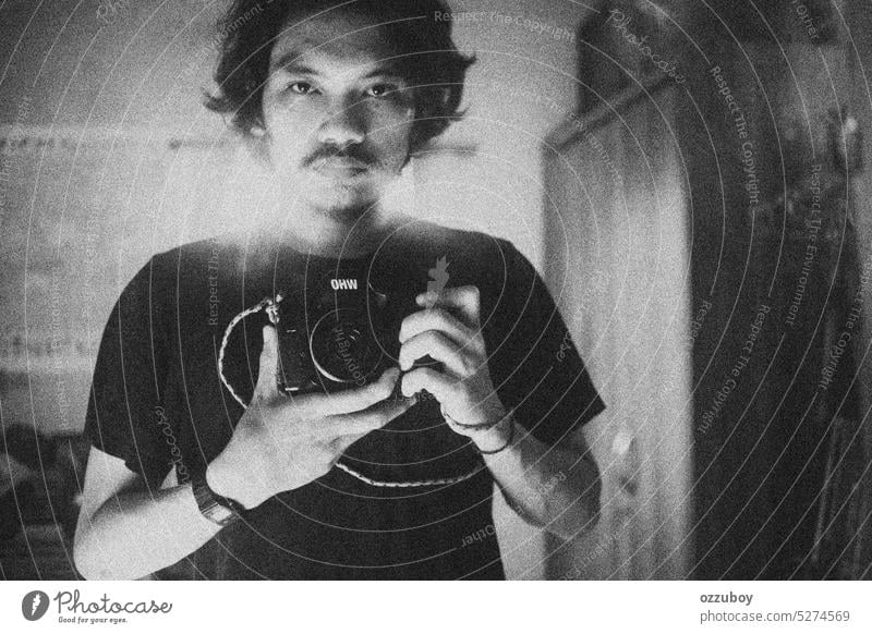 Self portrait of a photographer in the mirror person camera man lens male professional self lifestyle young adult photographing selfie reflection taking digital