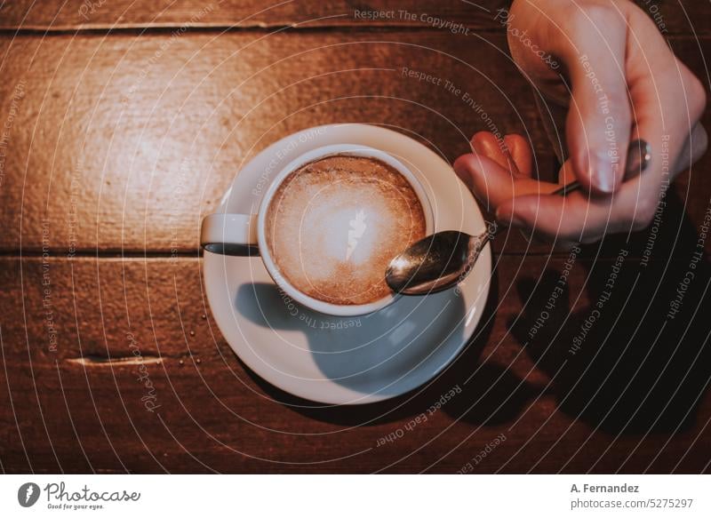 Male hand holding a small spoon next to a cup of coffee, seen from above Coffee Coffee break Coffee cup coffee shop Coffee mug coffee house Spoon Hand male Man