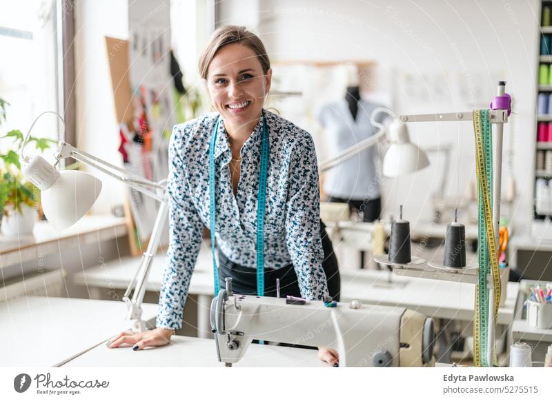 Young fashion designer at her workplace craft tailoring manufacturing handmade seamstress small business sewing machine workshop fabric hobby clothes material