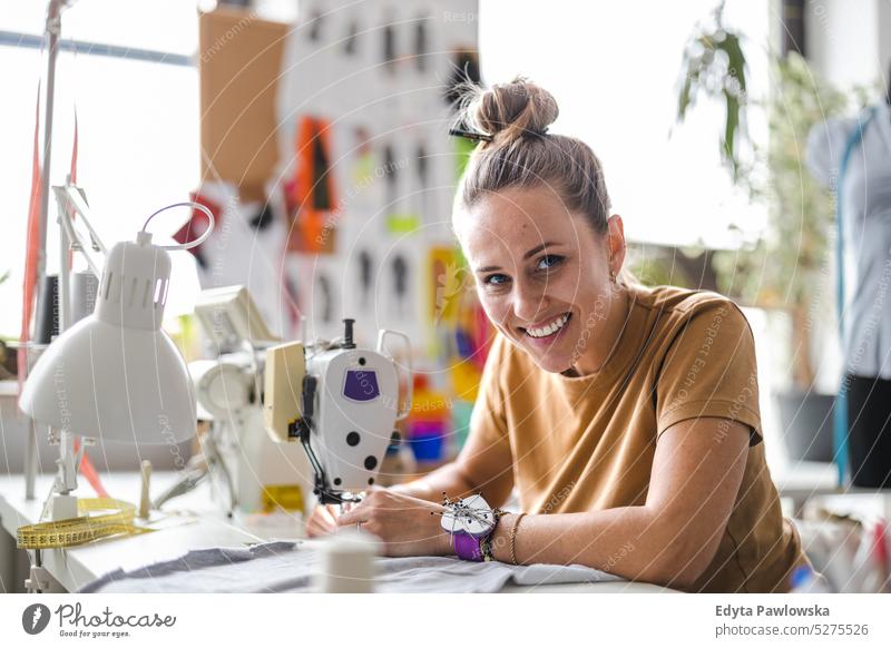 Fashion designer using a sewing machine at her workplace fashion designer craft tailoring manufacturing handmade seamstress small business workshop fabric hobby