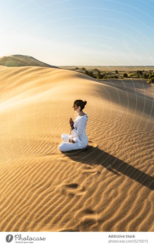 Woman gesticulating namaste in desert woman greeting mindfulness Vajrasana wellness sand wellbeing gesture yoga female pose vitality harmony meditate position