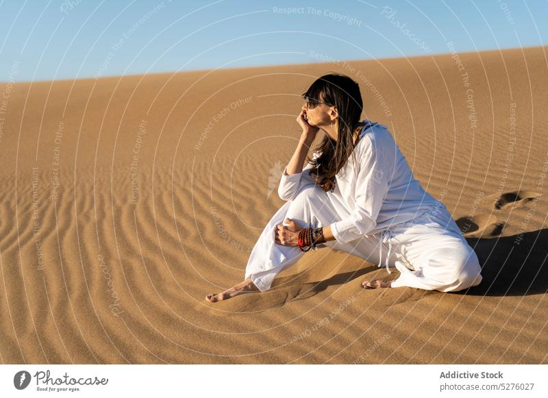 Female sitting on sand in desert woman vitality harmony female zen blue sky cloudless calm stress relief mindfulness idyllic peaceful heat frontera dry