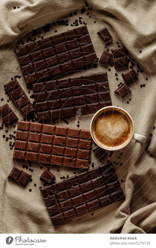 Cup of coffee near chocolate bars delicious tasty sweet dessert cup yummy drink beverage pastry table cappuccino cocoa mug aromatic cookie fresh food from above