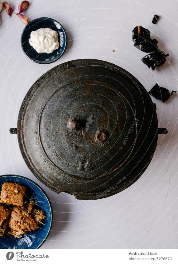 Cast iron cauldron on white table with ingredients cast iron dish pan food spanish cuisine bowl delicious tomato homemade meal spain tasty metal kitchen fresh