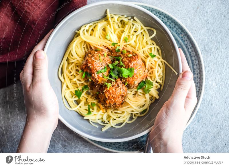 Anonymous cook with bowl with pasta and meatballs spaghetti concrete cooked coriander cuisine dinner food italian meal minimalism sauce stone tomato lunch