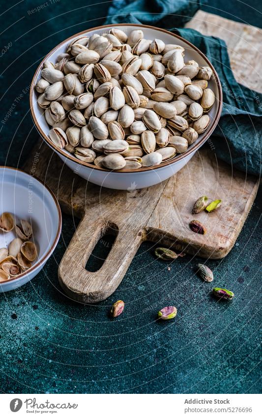 Organic and raw pistachio nuts assortment board bowl cutting board diet food healthy keto ketogenic meal fresh natural nutshell organic ingredient plant based