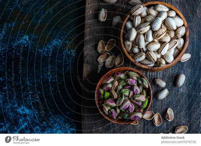Raw organic pistachio nuts in the bowl assortment background concept concrete cooking dark diet eat eating food green healthy keto ketogenic meal nutshell