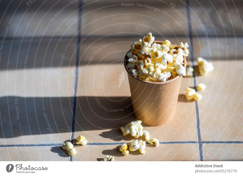 Paper cup with popcorn snack background ceramic cinema close up concrete container crusty eat eating fast food fluffy gourmet light meal movie paper pop corn