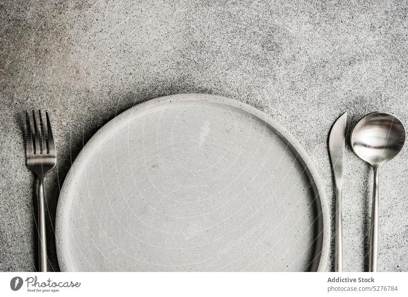 Minimalistic monochrome grey dinner set background ceramic concrete cutlery dinnertime dinnerware eat eating fork knife meal mealtime minimalism minimalistic