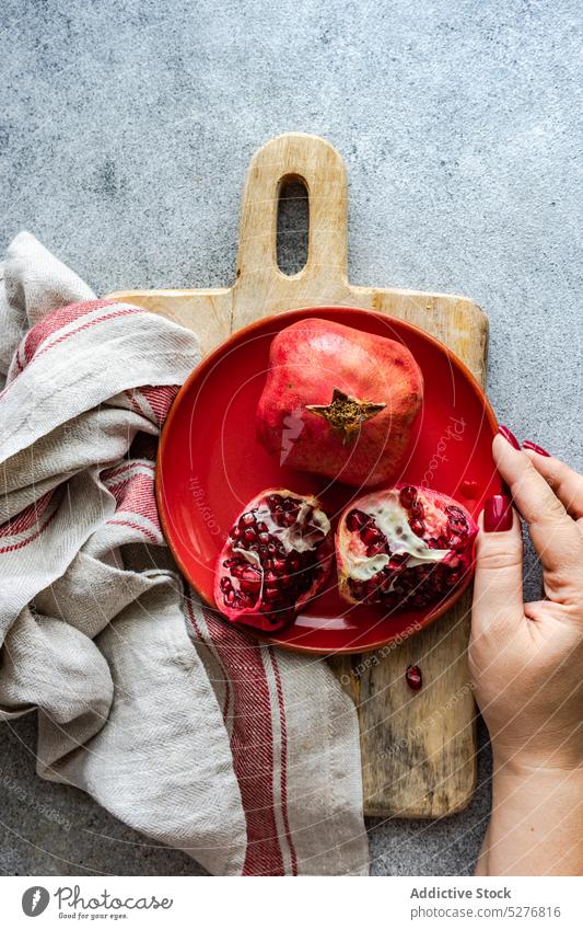 Minimalistic pomegranate raw fruit background bowl ceramic concept concrete dessert diet eat food gourmet grey group half hand healthy hold meal minimalism