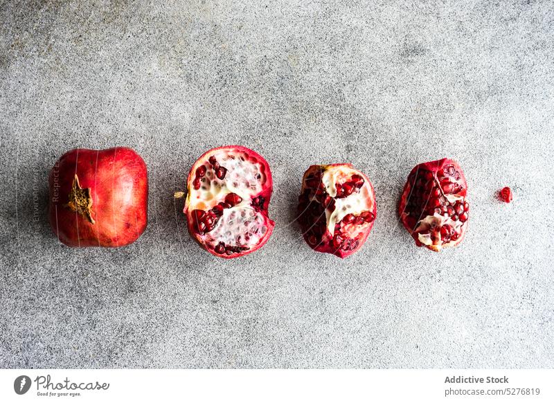 Minimalistic pomegranate raw fruit background concept concrete dessert diet eat food gourmet grey group half healthy meal minimalism natural organic piece