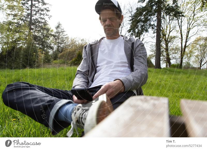 Sitting man with phone in greenery Telephone Cellphone Nature Man Lifestyle Technology smartphone Mobile Communication Human being using Equipment message