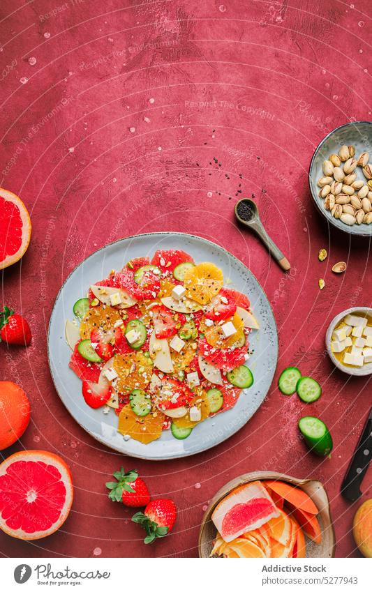 Delicious salad with fresh fruits apple cheese orange strawberry cucumber pistachios plate healthy healthy food delicious serve organic meal vitamin table diet