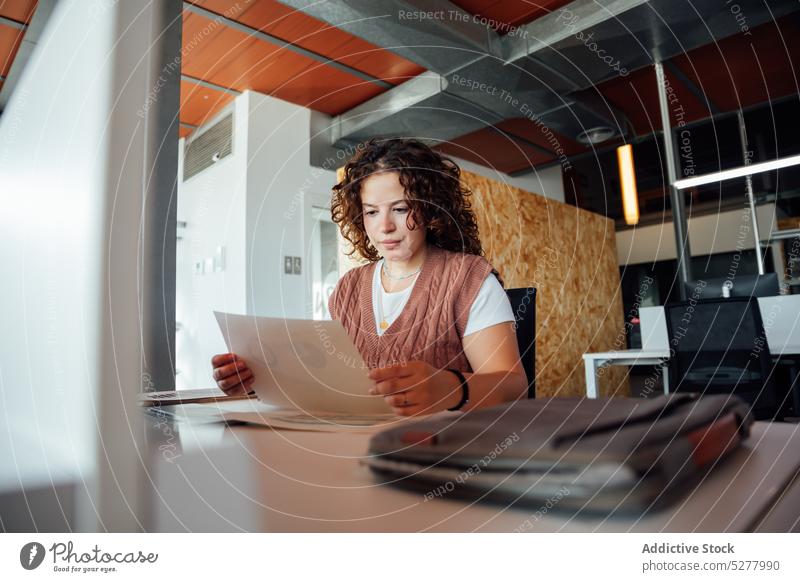 Young focused woman examining document with diagram read paper busy chart paperwork report finance business staff project career young occupation data graph