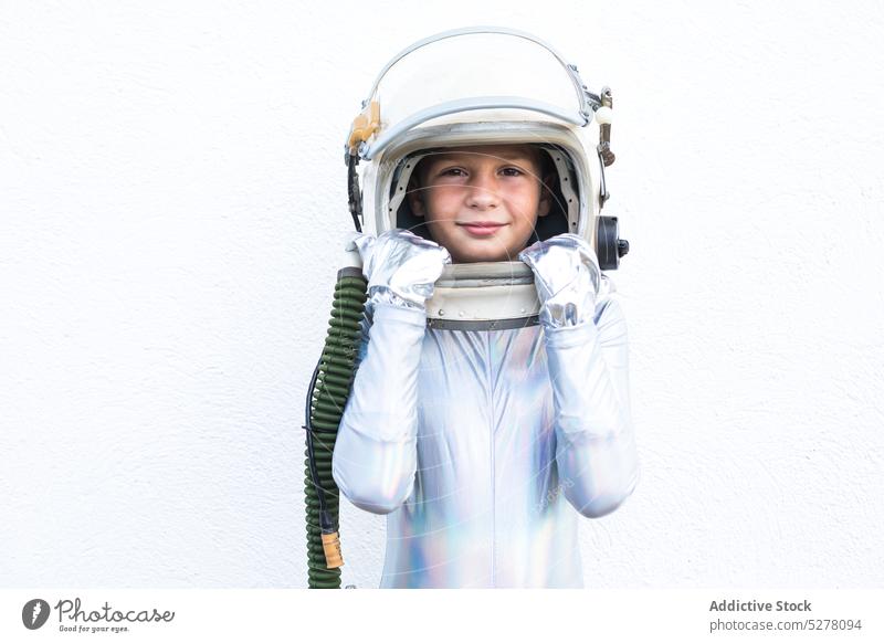 Boy in space suit looking at camera boy child cosmonaut astronaut smile spacesuit spaceman happy explorer futuristic thoughtful studio kid stand helmet preteen
