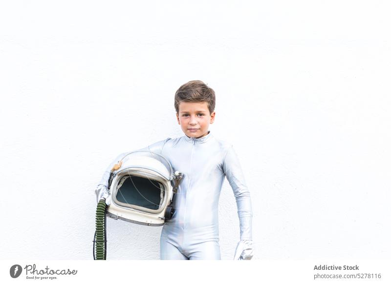 Kid in space suit standing on grassy ground boy child cosmonaut astronaut spacesuit spaceman kid explorer helmet wither futuristic costume future preteen
