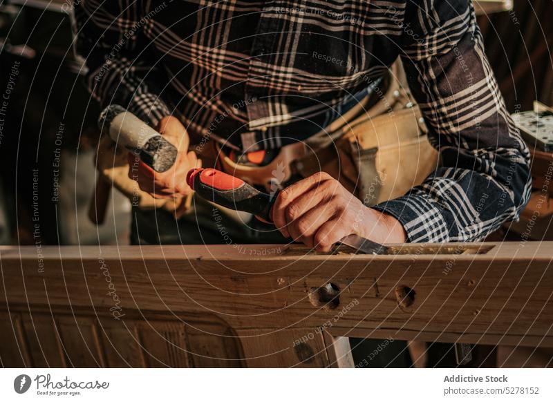 Crop carpenter using chisel in workshop man cut wood wooden plank joinery male woodwork craftsman woodworker job tool skill professional sharp lumber instrument