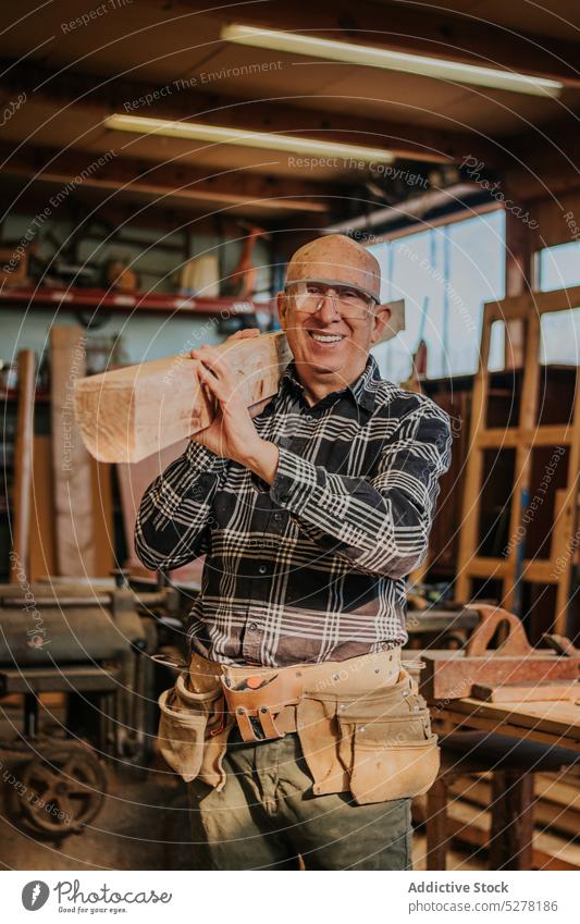 Craftsman working with wood in workshop carpenter joinery jointer smile professional woodwork protect wooden woodworker happy senior male elderly industry
