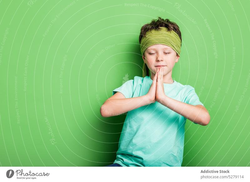 Peaceful boy with clasped hands prayer hands eyes closed sport calm martial studio shot peaceful concentration hands clasped unemotional kid child healthy