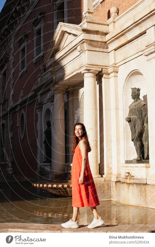 young woman in red dress near fountain. Female tourist posing for photoshoot. Fashion and style. Tourism Tourist travel outdoors lifestyle summer vacation