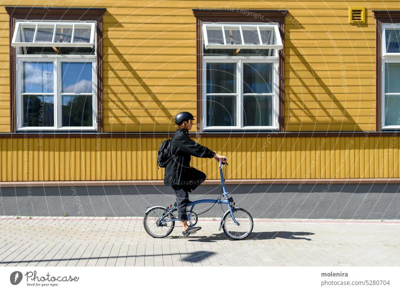 Woman riding on bicycle at city woman female activity helmet lifestyle citizen artist romance summer enjoying individuality beauty 30s sunny action