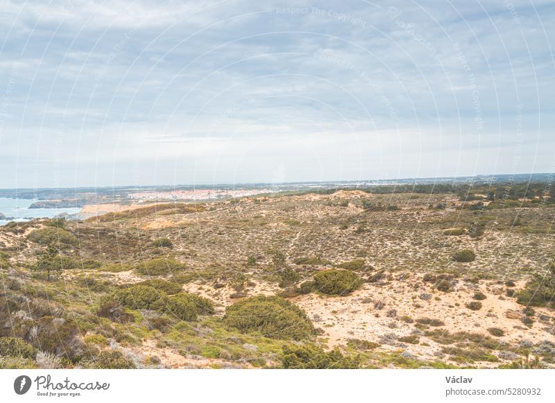 Scenery of the dry steppe in the west of Portugal in the Odemira region. View of fields, city and Atlantic Ocean. Following the Fisherman trail, Rota Vicentina
